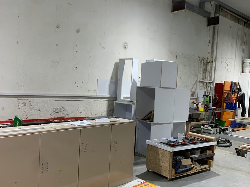 Base cabinets on protective cardboard on the workshop floor