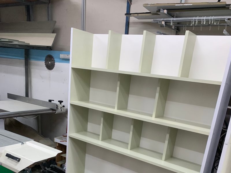 Pale green bookcase carcass standing in the workshop