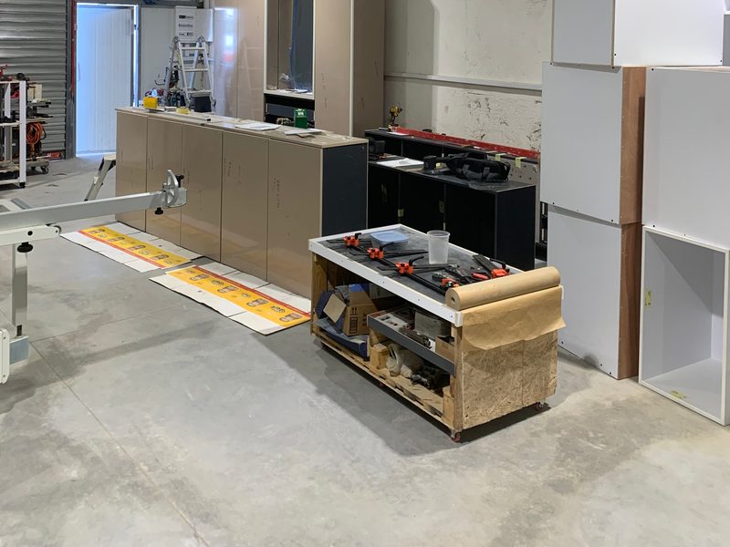 Wide view of cabinets being assembled across the workshop