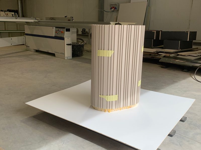 Fluted column cladding on a white board, seen from the side