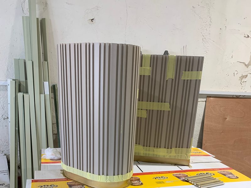 Two fluted cabinet pieces taped up on trestles