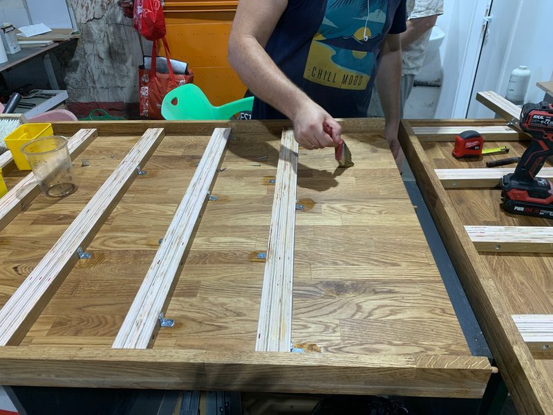 Hands at work on a wood worktop with battens laid across it