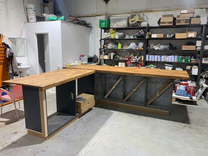 L-shaped counter frame with a wood-look top, being built in the workshop
