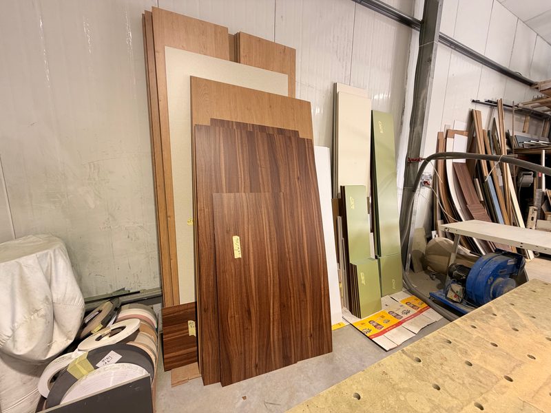 Sheet materials and offcuts stacked against the wall