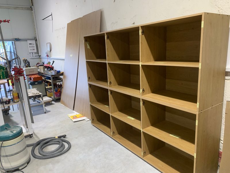 Wood-grain shelving unit with a dust extractor in front