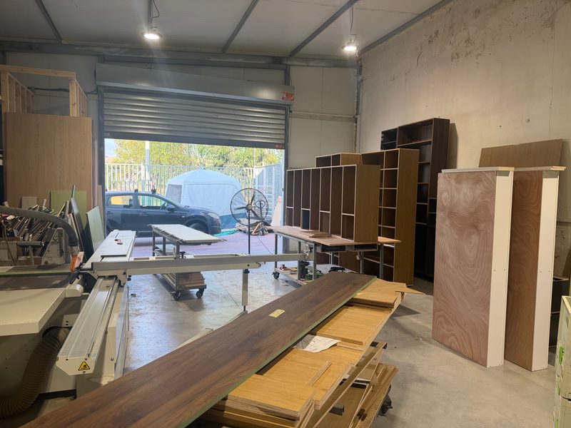 Workshop with shelving units, plywood panels and boards on a cart