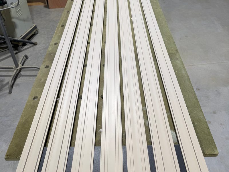 Long slatted panels laid out on the workshop floor
