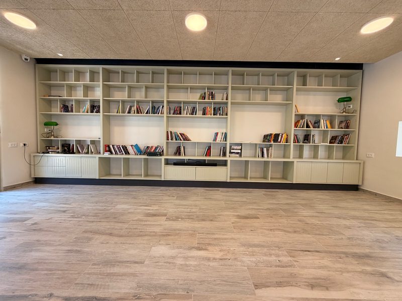 Long wall of built-in open shelving with cabinets below