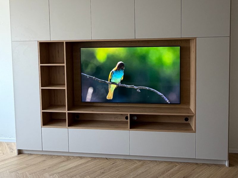 Floor-to-ceiling TV wall unit with light doors and open shelves