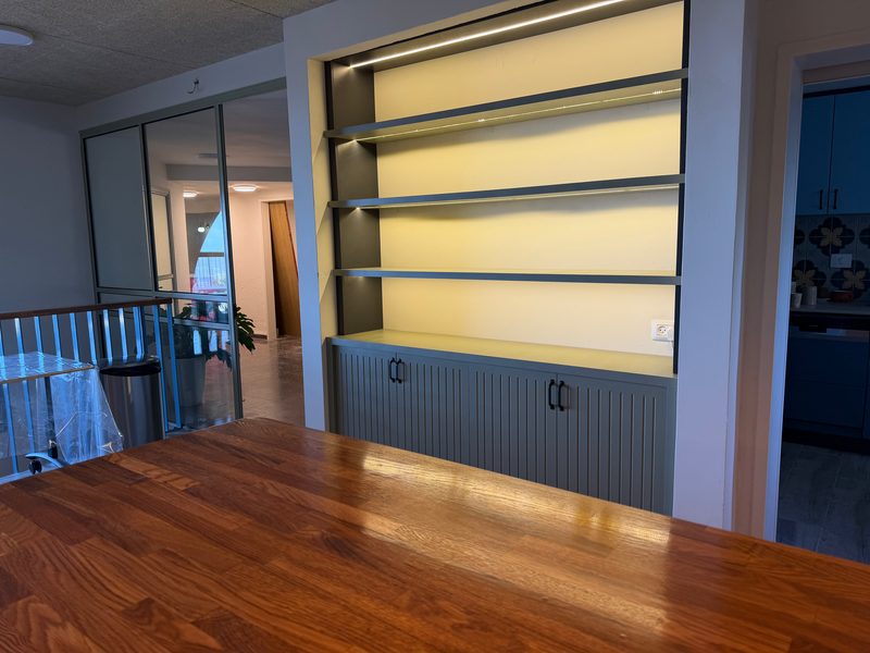 Lit shelves above grooved cabinets