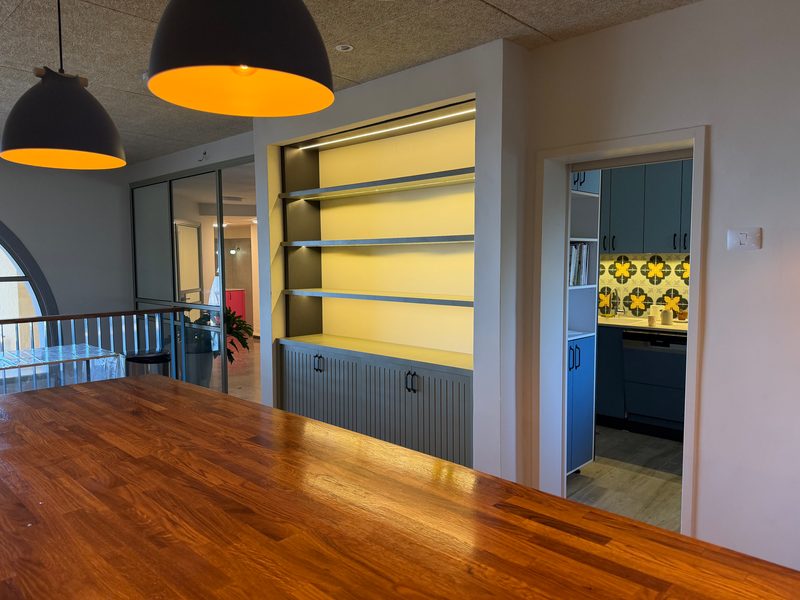 Lit shelving unit, pendant lights above