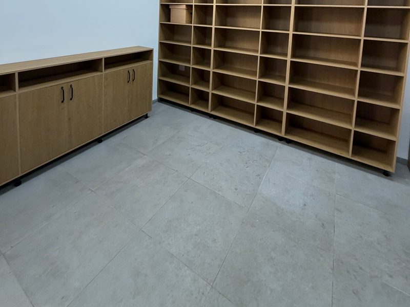 Shelving wall with low cupboards beside it