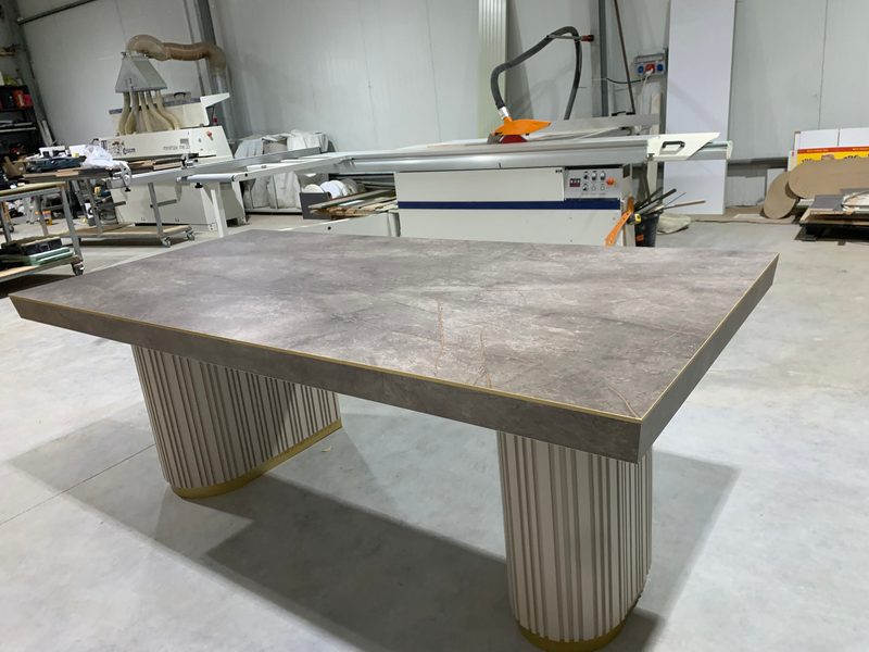 Table with a stone-look top on two grooved round bases, in our workshop