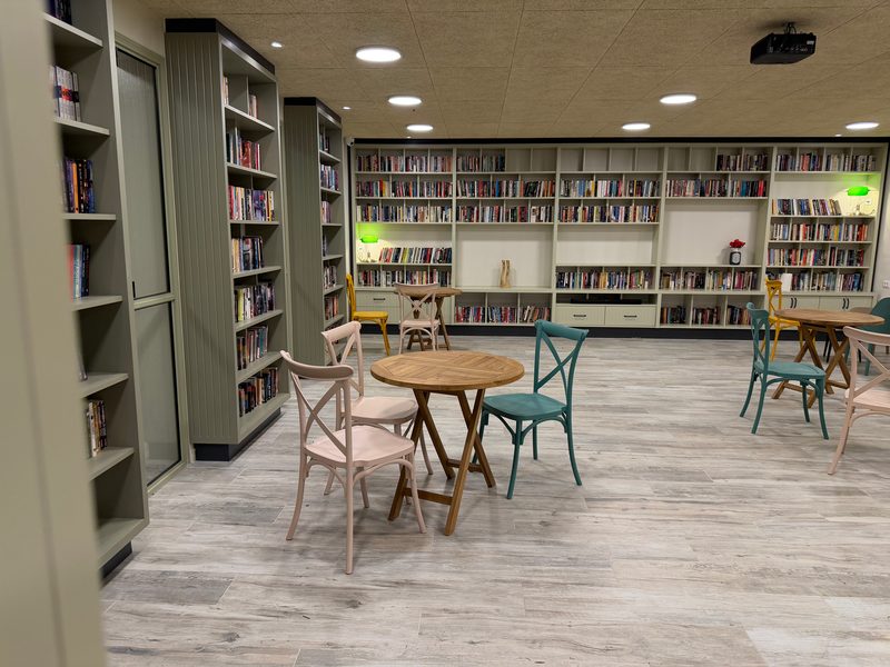 Tall bookcases and a full shelving wall around a seating area